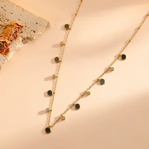 Close-up of French style gold stainless steel necklace with black charms and diamonds