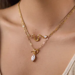 Detail of layered gold snake necklace with marquise and teardrop zircon pendants