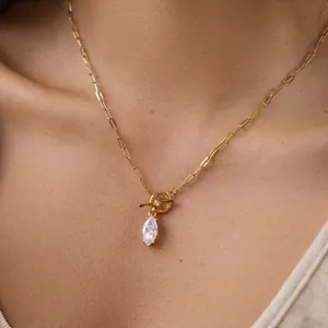 Close-up of gold-plated paperclip chain necklace with marquise zircon pendant on model