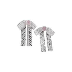Eleganti orecchini a fiocco in argento con pietre rosa e intricati dettagli filigranati.