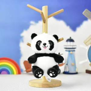 Gros plan d'un adorable porte-clés en peluche panda suspendu sur un support en bois déco
