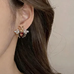 Vintage gold bee earrings with crystal wings and red enamel for a luxury look.