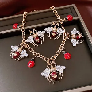 Vintage-inspired insect jewelry set with crystal bee and enamel ladybug charms in gold finish