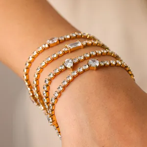 Détail de bracelets tennis dorés avec zircons en forma de cœur et de poire