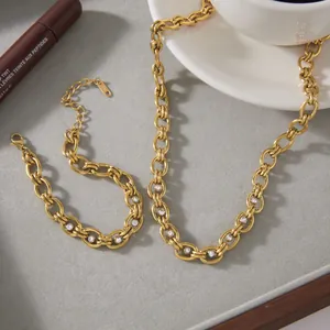 Gros plan d'un ensemble collier et bracelet maille cubaine en acier doré et zircons