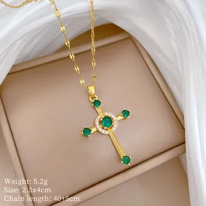 Close-up of gold cross pendant with green zircons on silk background jewelry box