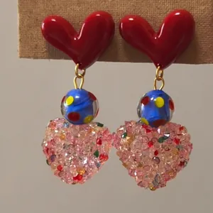 Detail shot showing the texture of colorful crystal heart earrings with resin tops