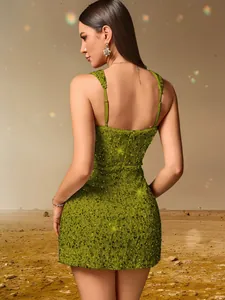 Détail d'une mini robe verte à paillettes dos nu sexy avec de fines bretelles