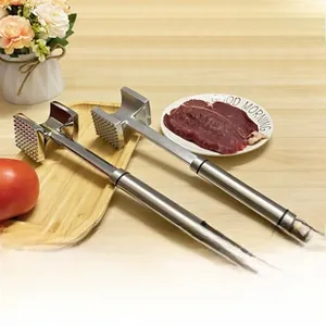 Dual-sided stainless steel meat tenderizer hammers on a table with a prep plate