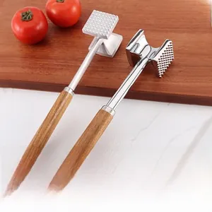 Detail of dual meat tenderizers with spiked metal heads and wooden handles on board