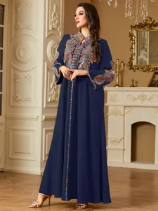 Detail der bunten ethnischen Stickerei auf dem langärmeligen marineblauen Kaftan-Maxikleid