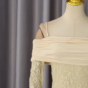 Détail de la combinaison blanc cassé avec manches en dentelle florale et col bardot