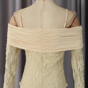 Détail du haut en dentelle blanc cassé avec col drapé et épaules dénudées à texture fine