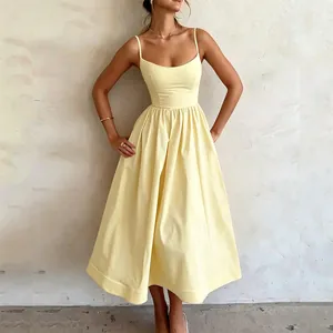 Détail d'une robe midi plissée jaune pâle à taille haute avec de fines bretelles