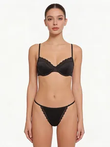 Detail of sexy black satin bra and thong set with elegant eyelash lace trim accents