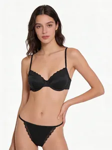 Detailed macro view of black satin lingerie set with eyelash lace trim and underwire support