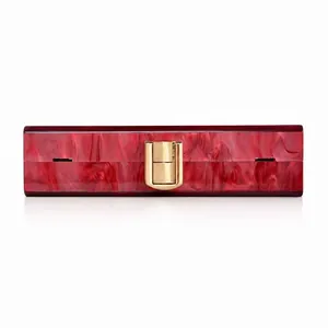 Dettaglio della pochette da sera in acrilico marmo rosso con chiusura dorata di lusso