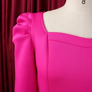 Detail von Karree-Ausschnitt und Puffärmeln an einem lebhaften rosaroten Kleid