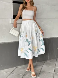 Detail of white high-waist midi skirt featuring blue floral print and white button closure