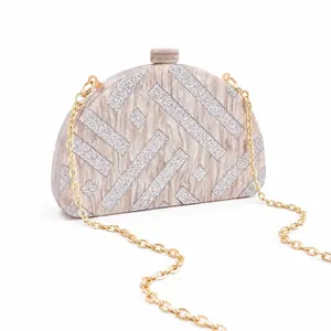 Detail of semi-circular acrylic evening clutch with marble texture and golden chain