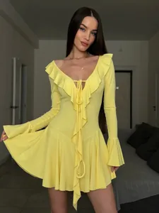 Close-up of bright yellow V-neck dress with ruffle trim and bell sleeve details