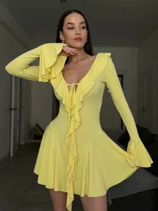 Detailed view of yellow V-neck mini dress featuring ruffled trim and wide bell sleeves