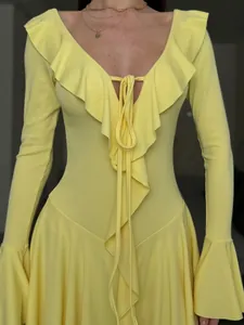 Detail of ruffled V-neckline with tie knot and flare sleeves on yellow spring dress