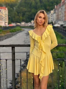 Detail of yellow dress featuring ruffled neckline and delicate front tie strings