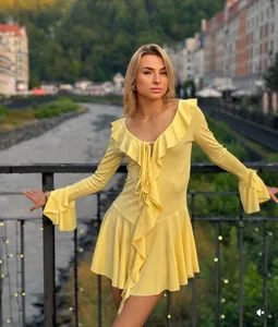 Detail of V-neckline with ruffles and drawstring on a bright yellow slim-fit dress