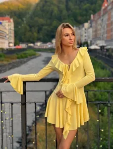 Detail of ruffled deep V-neckline and trumpet sleeves on a slim fit yellow dress