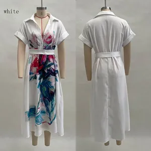 Details des weißen Hemdkleids mit bunten Blumendrucken und passendem Taillengürtel