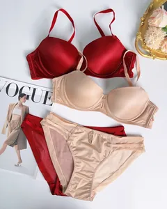 Flat lay of seamless push-up lingerie sets in burgundy and beige with glossy finish