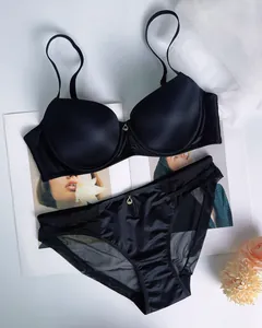 Detailed flat lay of black seamless lingerie set with satin finish and mesh panels