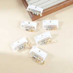 Minimalist stainless steel earring set featuring gold and silver geometric studs and rings