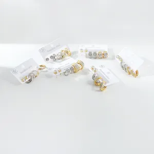 Detail of stainless steel earring set with gold and silver finishes and zircon stones