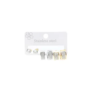 Detail of stainless steel earring set featuring gold and silver studded hoops and studs