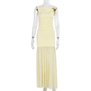 Detail of light yellow ruched evening dress featuring an asymmetrical neckline and gold buckle