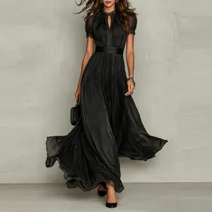 Detail of black V-neck maxi dress with lace embroidery and flowing pleated skirt