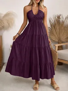 Detail of deep purple halter neck dress featuring layered tier design and pleated texture