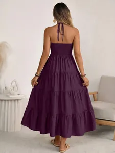 Back view of a deep purple halter neck tiered maxi dress with smocking and open back detail