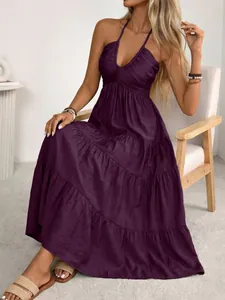 Detail of dark purple halter neck maxi dress with layered ruffle skirt and v-neckline