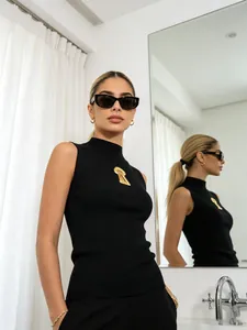 Chic gilet noir sans manches à col roulé avec un ornement métallique doré en trou de serrure
