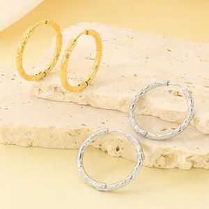 Dettaglio di orecchini a cerchio in acciaio inossidabile con motivo diamantato