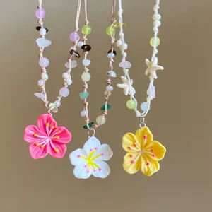 Close-up detail of colorful dopamine flower pendants and starfish beads on necklaces