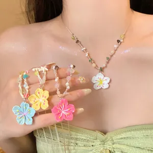 Detailed view of colorful flower pendant necklaces with beaded chains