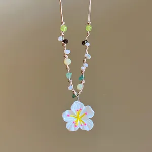 Close-up of a handmade colorful flower beaded necklace with white floral pendant