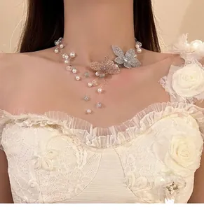 Vue détaillée d'un collier de perles style fée avec breloques papillon en cristal