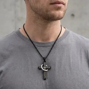 Primer plano de un collar de cruz para hombre en acero inoxidable negro con un anillo entrelazado.