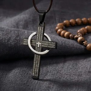 Detalle de cerca de un colgante de cruz de acero inoxidable negro con accesorio de anillo plateado