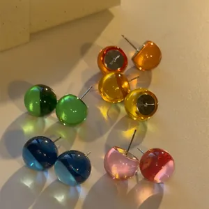 Detailed view of colorful translucent sphere stud earrings in various summer fruit shades